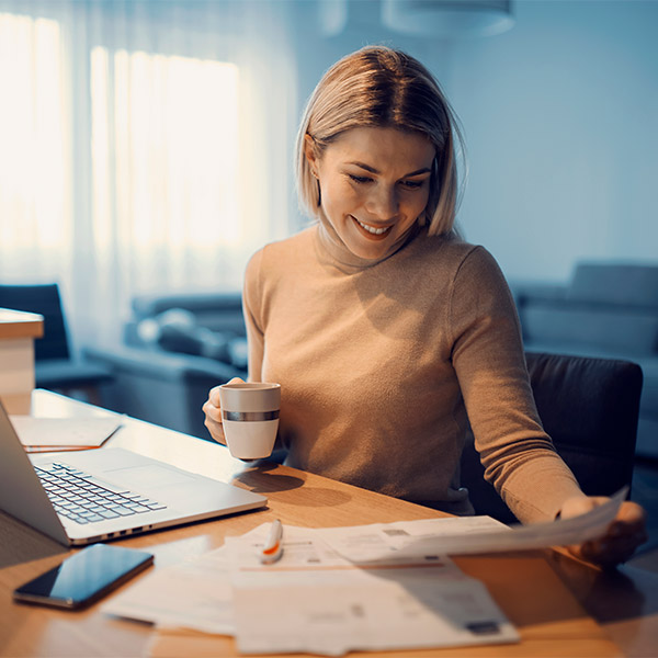 woman looking at loan options while drinking tea