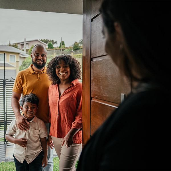 family of three opening the front door to their new home